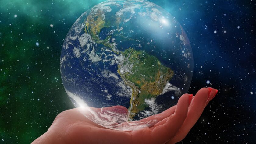 A symbolic image showing a hand gently holding the Earth, representing the power of unity and care in creating a harmonious global society.